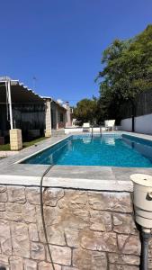 a swimming pool with a stone wall around it at Villa Jazmín - Piscina - BBQ - Jardín - Chill out in Masía Aldamar