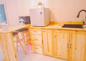 a kitchen with a refrigerator on top of a counter at NonaStudio Myra Park Nilai 3 in Nilai +7 photos