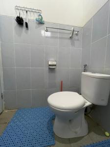 ein Badezimmer mit weißer Toilette und blauem Boden in der Unterkunft Cozy Homes BnB in Prampuan + 22 Fotos