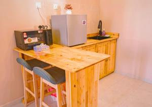 a kitchen with a wooden table and a refrigerator at NonaStudio Myra Park Nilai 3 in Nilai