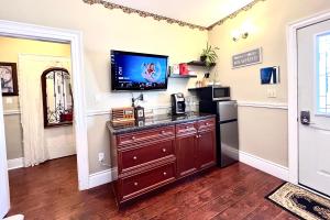 a kitchen with a tv on the wall and a refrigerator at Barker House 3# Suite-heart of oldtown in Niagara on the Lake