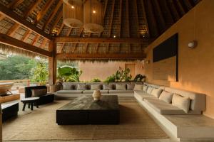una sala de estar con un sofá y una mesa en Casa Yute by Ahau Collection, en San Agustinillo