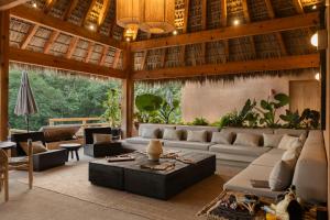 una sala de estar con un sofá y una mesa en Casa Yute by Ahau Collection, en San Agustinillo