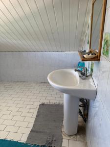 un baño con lavabo y espejo en Dortoir 1, en Faaa