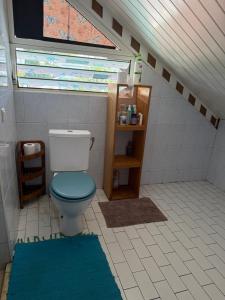 y baño con aseo y ventana. en Dortoir 1, en Faaa