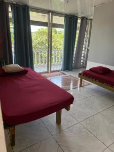 Un dormitorio con una cama y una ventana con balcón. en Dortoir 1, en Faaa