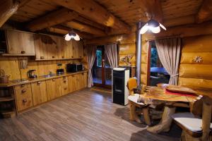 Forest Glade Cottage - Koča na jasi في Rečica ob Savinji: مطبخ مع طاولة وغرفة طعام