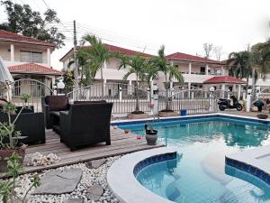 a swimming pool in a yard with chairs and a house at Pool Villa 91 in Ban Nong Pru +4 photos