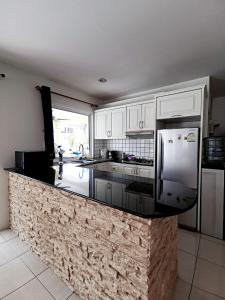 a kitchen with white cabinets and a granite counter top at Pool Villa 91 in Ban Nong Pru