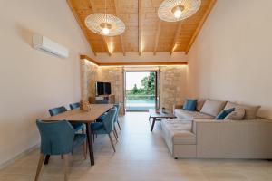 a living room with a table and chairs and a couch at Pithari Stone Villa in Khalikerí