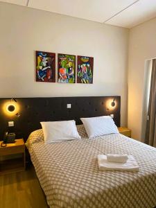 a bedroom with a bed with two white towels on it at GUMBELA - Hotel in São Tomé