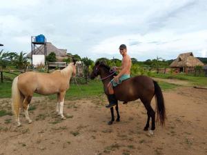 Un joven montado a caballo junto a un caballo. en Finca Buena Vida, en Popoyo 11 fotos más