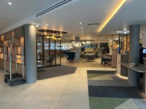 Un vestíbulo con mesas y sillas en un edificio. en London Luton Vale Hotel, en Luton