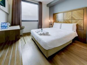 a hotel room with a large bed and a desk at B&B HOTEL Padova in Padova