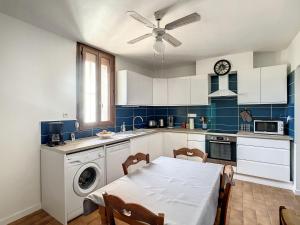 cocina con mesa y cocina con ventilador de techo en Quai n16 - Lieu atypique pour un séjour au calme, en Aramon