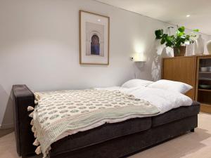 Un dormitorio con una cama con una manta encima. en New modern apartment, en Bergen