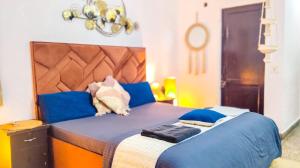 a bedroom with a large blue bed with blue pillows at Indraprastha BNB Home in New Delhi