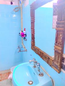 a bathroom with a blue sink and a mirror at Indraprastha BNB Home in New Delhi +16 photos