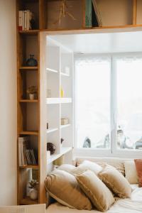 Front de mer - Studio RDC - Centre-ville & Casino في لوك-سور-مير: سرير مع وسائد في غرفة مع نافذة