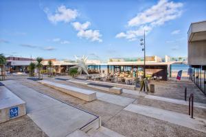 Front de mer - Studio RDC - Centre-ville & Casino في لوك-سور-مير: منتجع فيه طاولات وكراسي في حديقة