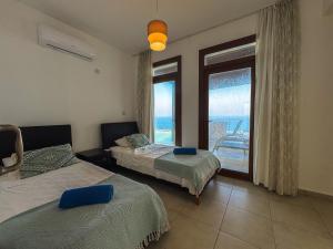 a bedroom with two beds and a view of the ocean at Villa Sea Cliff 1 in Kyrenia