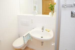 ein Badezimmer mit einem Waschbecken, einem WC und einem Spiegel in der Unterkunft Ferienwohnung Heigel in Oberstdorf