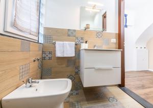 un bagno con un lavandino bianco e uno specchio di Terrazza in Centro - Casa Torres ad Acireale