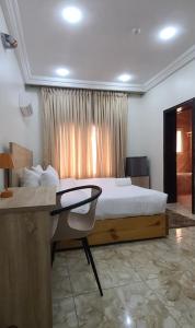 1 dormitorio con 1 cama y escritorio con escritorio en Merrigold Resorts, en Gbogije