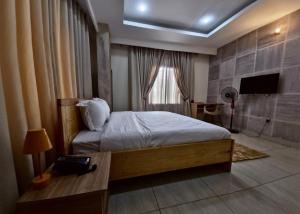 Un dormitorio con una cama y una ventana y un televisor. en Merrigold Resorts, en Gbogije