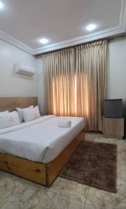 Un dormitorio con una cama grande y una ventana grande. en Merrigold Resorts, en Gbogije