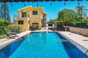 a villa with a swimming pool in front of a house at Villa Dunya in Kyrenia +15 photos