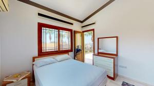a bedroom with a white bed and a mirror at Villa Dunya in Kyrenia