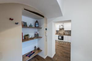 un soggiorno con pareti bianche e pavimenti in legno e un corridoio di Terrazza in Centro - Casa Torres ad Acireale Altre 11 foto