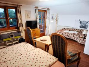 Pension Rennlehen Ferienwohnungen في بيرتشسغادن: غرفة نوم بها سرير وطاولة وكراسي
