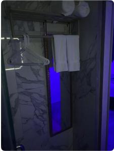 a bathroom with a towel rack and a mirror at The Sky High Escape - 5 Mins from Airport & Beaches in Bon Accord