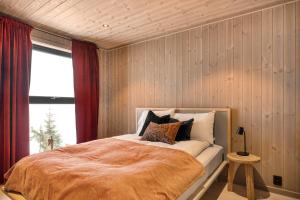 a bedroom with a large bed with a red curtain at Trysil hytteomrade 2041 by Vacation Trysil in Hovi