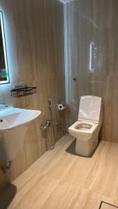 a bathroom with a white toilet and a sink at Luxury Apartment شقه الفخامه في المونسيه in Riyadh +14 photos