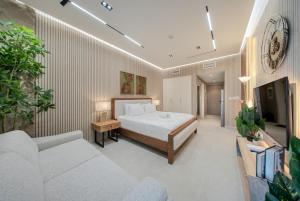 a bedroom with a bed and a couch and a tv at Amazing Studio in Areej Aljada in Sharjah