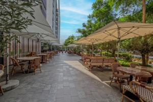 an empty patio with tables and chairs and umbrellas at Amazing Studio in Areej Aljada in Sharjah
