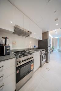 a kitchen with a stove and a microwave at Amazing Studio in Areej Aljada in Sharjah