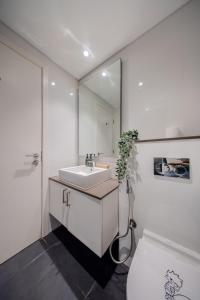 a white bathroom with a sink and a mirror at Amazing Studio in Areej Aljada in Sharjah +26 photos