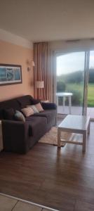 a living room with a couch and a table at Studio face à l océan in Les Sables-dʼOlonne
