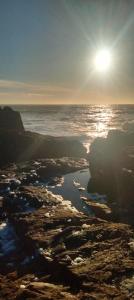 a view of the ocean with the sun in the sky at Studio face à l océan in Les Sables-dʼOlonne