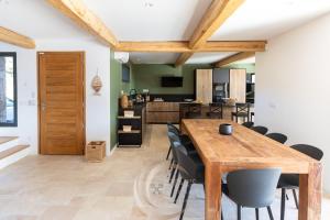 a kitchen and dining room with a wooden table and chairs at Villa Neuve Corse sud avec vue mer et piscine chauffée in Pianottoli-Caldarello