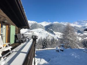 a snow covered balcony with a view of a mountain at Chalet les Mélèzes - Typique, terrasse & cheminée in Liddes