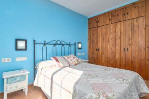 ein Schlafzimmer mit einem Bett und einer blauen Wand in der Unterkunft Villa La Canarita in La Cala del Moral + 30 Fotos