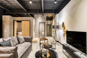 a living room with a couch and a tv at Downtown Designer Apartments by ULIV in Tijuana