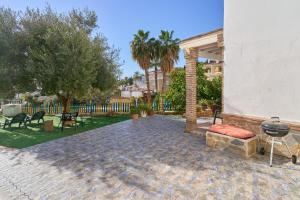 eine Terrasse mit Grill, Stühlen und Bäumen in der Unterkunft Villa La Canarita in La Cala del Moral