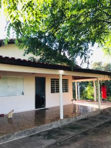 a house with a cat sitting in front of it at Casa de campo in Botucatu