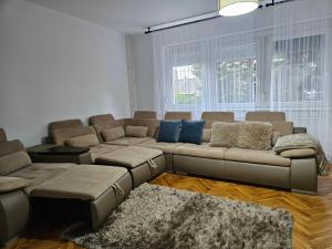 a living room with a sectional couch and blue pillows at FAMILLE Apartman in Tapolca